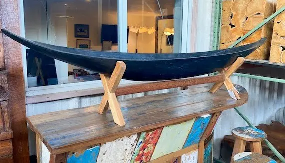 A boat on display in front of a window.