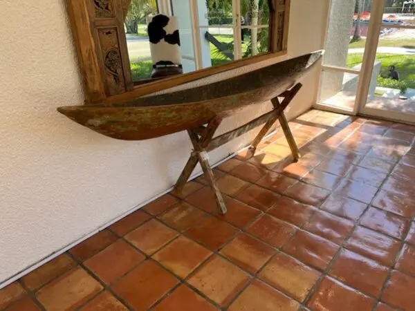 A wooden boat sitting on top of a tile floor.