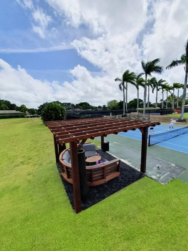 Wooden pergola with seating area outdoors.