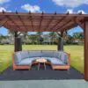 Cozy outdoor seating under wooden pergola.