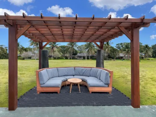 Cozy outdoor seating under wooden pergola.