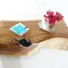 A wooden table with a vase of flowers on top.