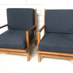 Two chairs with blue cushions on a white floor.