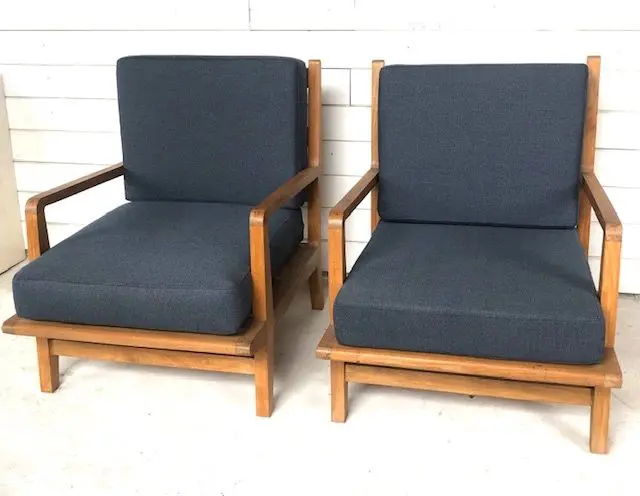 Two chairs with blue cushions on a white floor.