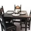 A table with four chairs and plates on top of it.