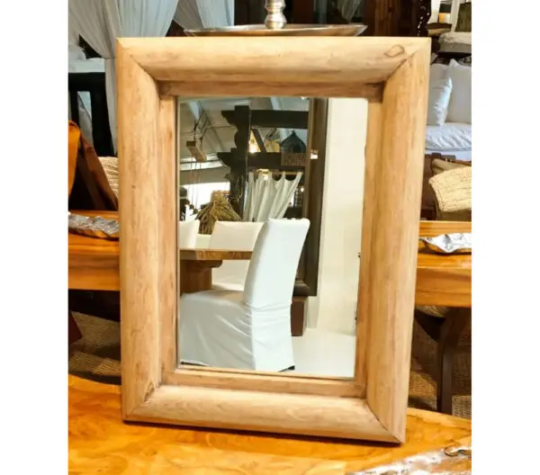 A mirror sitting on top of a wooden table.