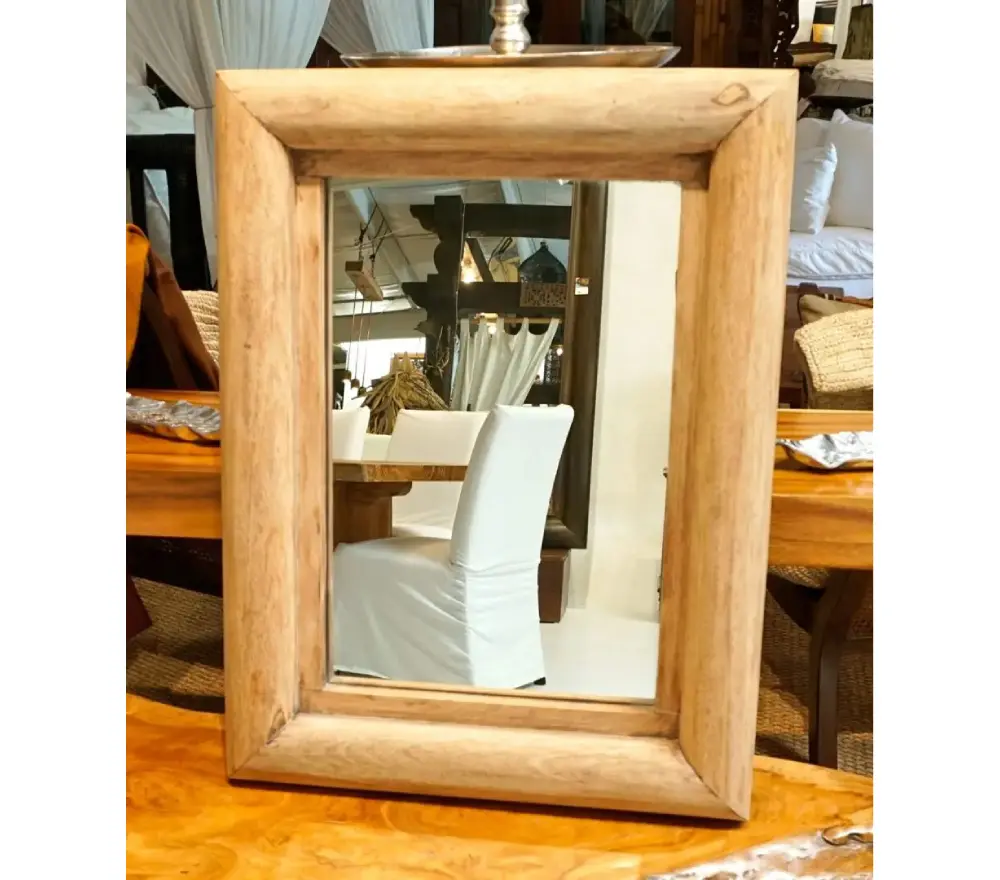 A mirror sitting on top of a wooden table.