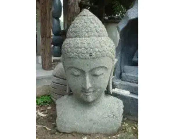 A statue of buddha is shown in front of trees.