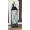 A tall black lantern sitting on the ground.