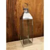 A metal lantern sitting on top of a wooden table.