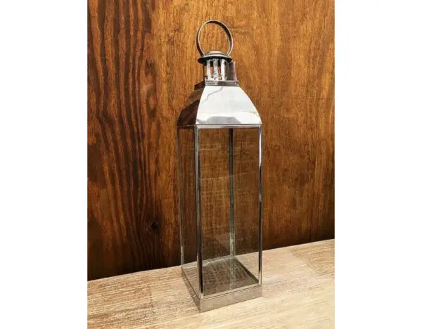 A metal lantern sitting on top of a wooden table.