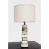 A table lamp with a white shade on top of a black table.