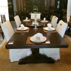 Elegant dining table set with white chairs.