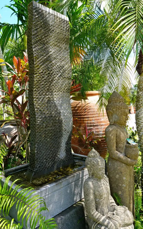 Buddha statues beside a decorative fountain.