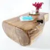 A wooden table with a vase of flowers on top.