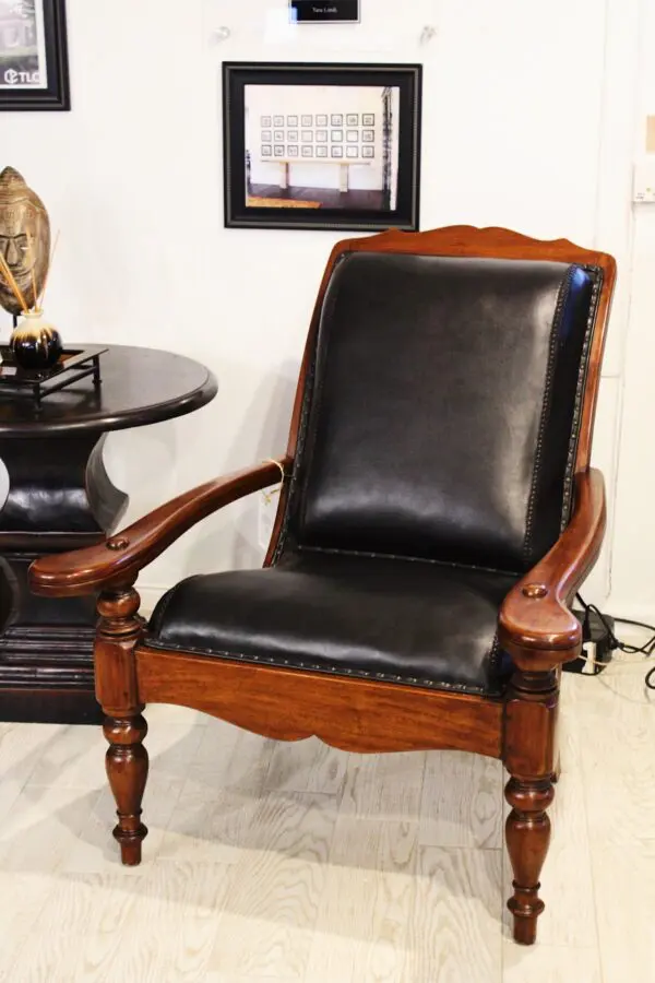 Black leather armchair with wooden legs.