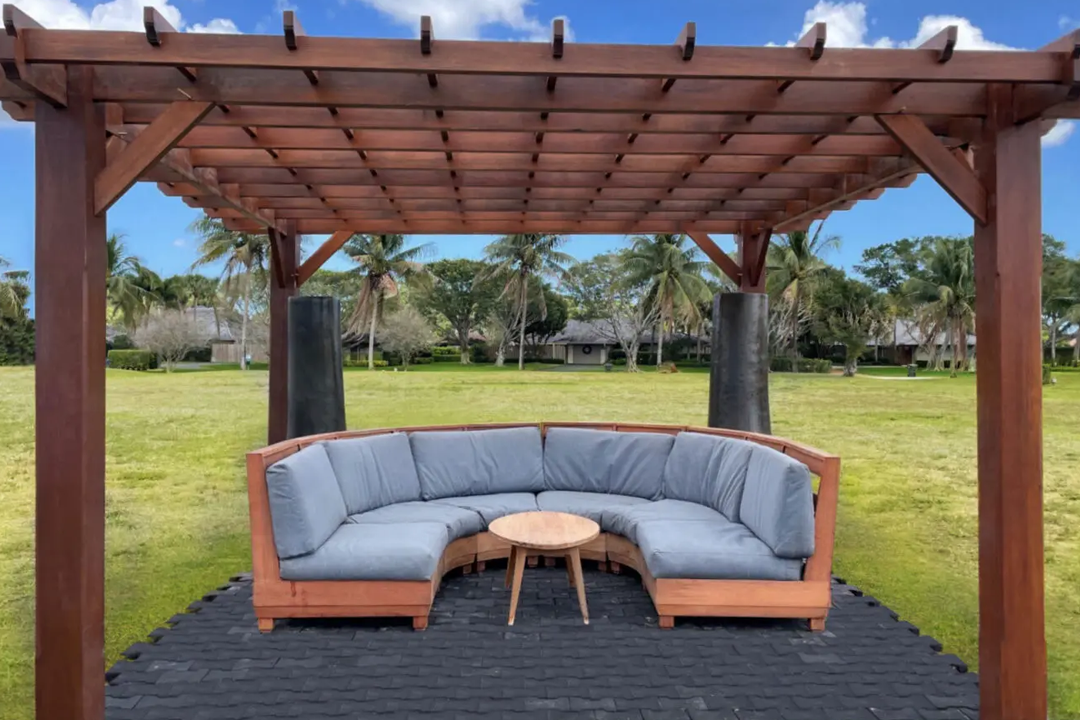 Wooden pergola with a curved sofa set.