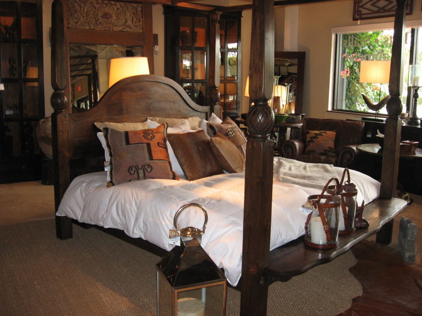 A bedroom with four poster bed and large mirror.