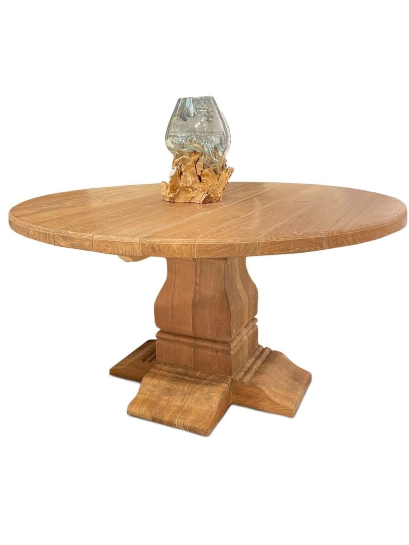A round table with a glass vase on top of it.