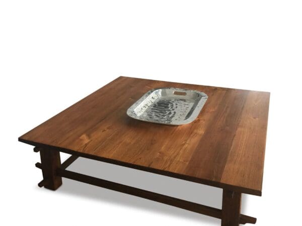 A wooden table with a metal tray on top of it.