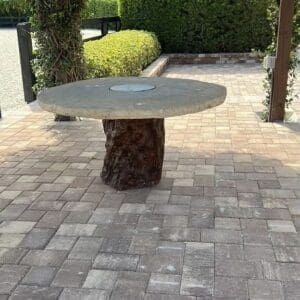 A table made out of tree trunks and concrete.