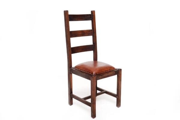 A wooden chair with brown leather seat.