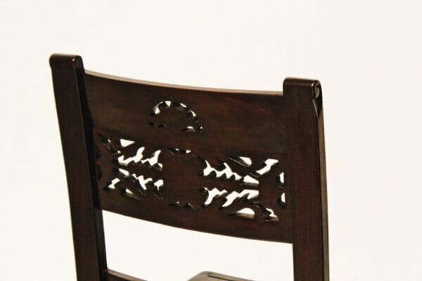 A close up of the back of a wooden chair