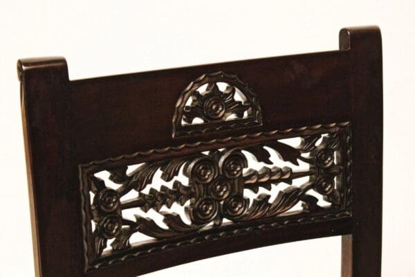 A close up of the ornate metal work on the back of a chair.