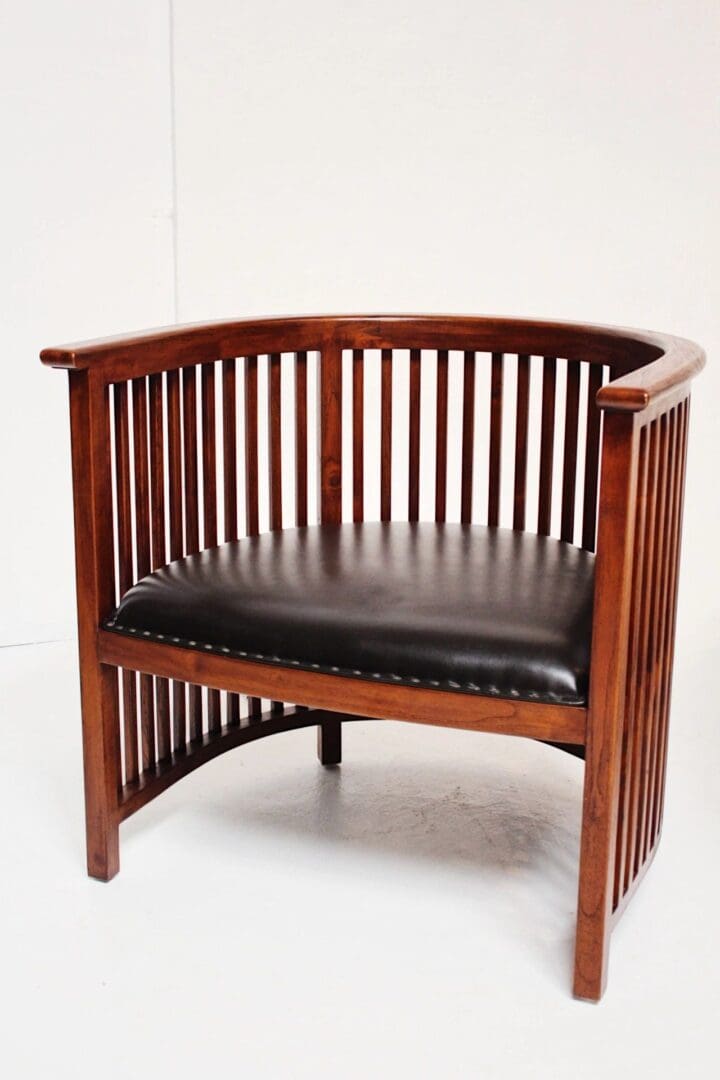 A wooden chair with black leather seat.