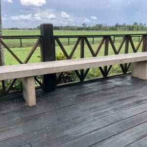 A wooden bench on the side of a deck.