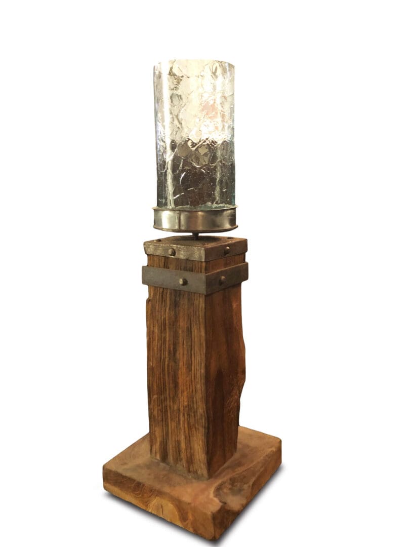 A wooden pillar with a glass cylinder on top.