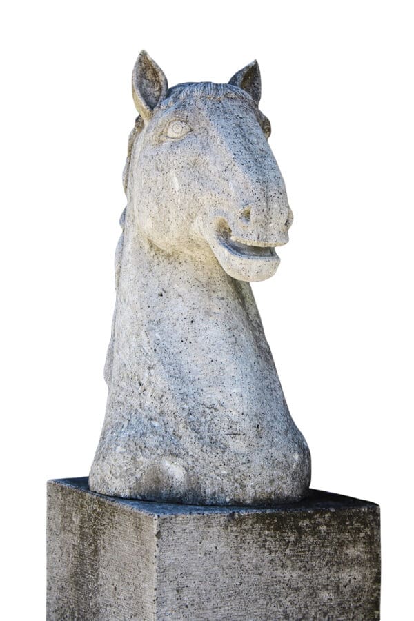 A horse statue sitting on top of a stone slab.