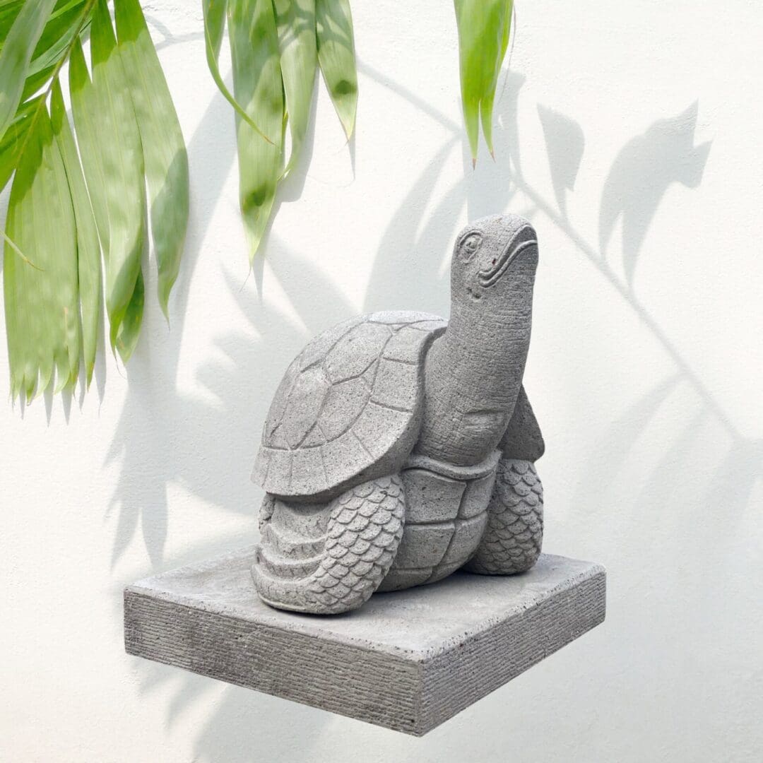 A turtle statue sitting on top of a stone slab.