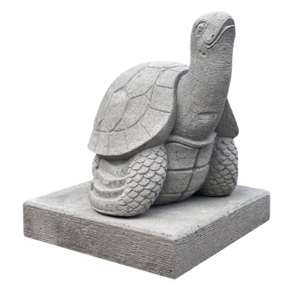 A statue of a turtle sitting on top of a stone slab.