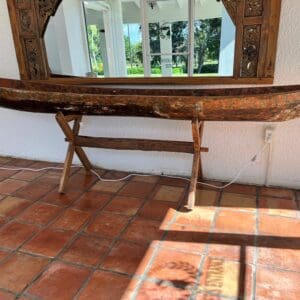 A mirror sitting on top of a wooden table.