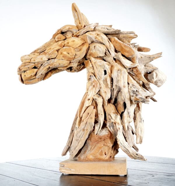 A horse head made of wood on top of a table.