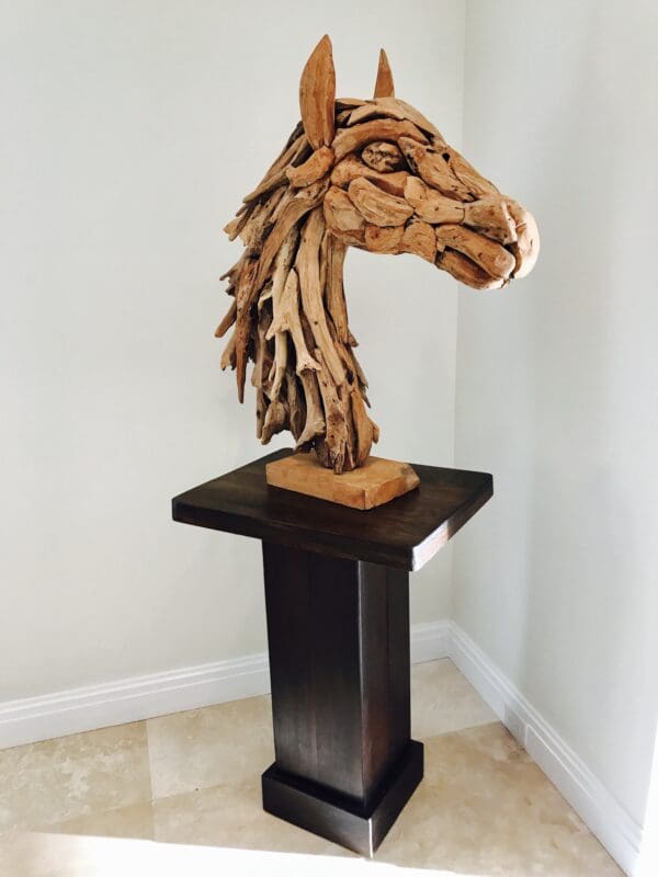 A wooden horse head sculpture on top of a table.