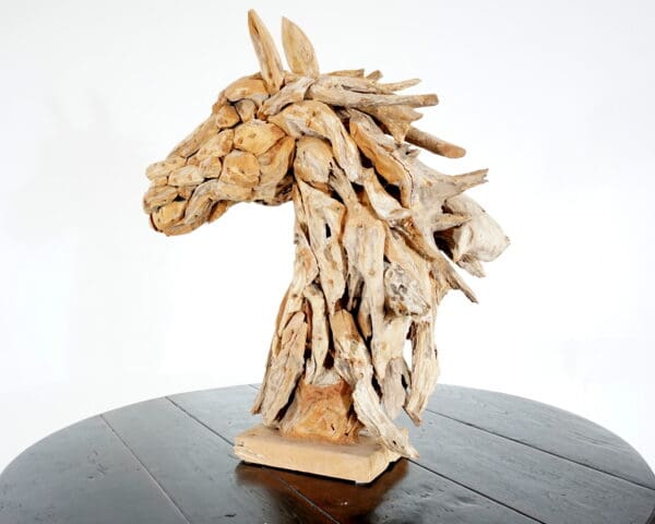 A wooden horse head sculpture on top of a table.