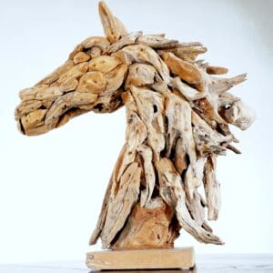 A horse head made of wood on top of a wooden base.