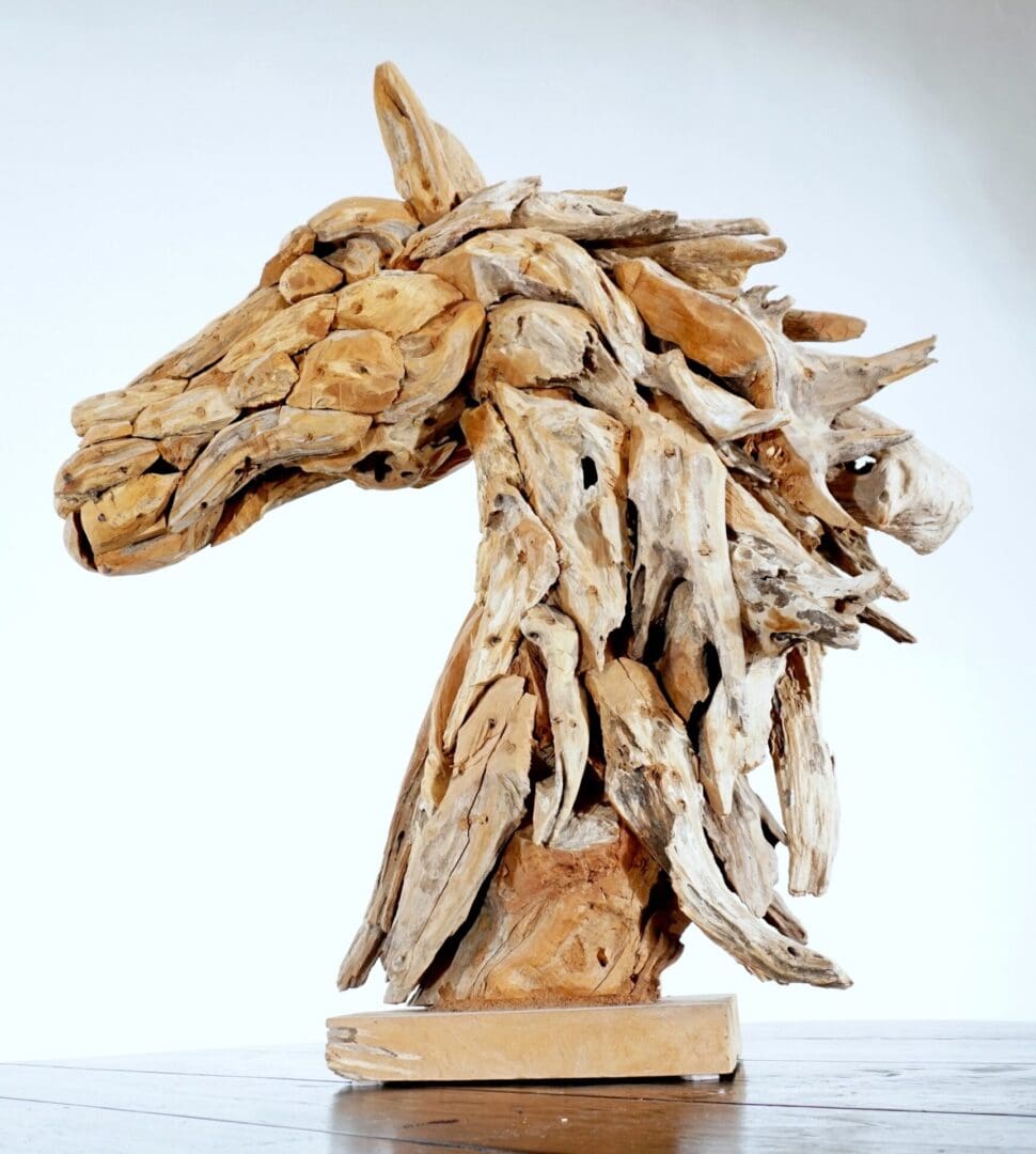 A horse head made of wood on top of a wooden base.