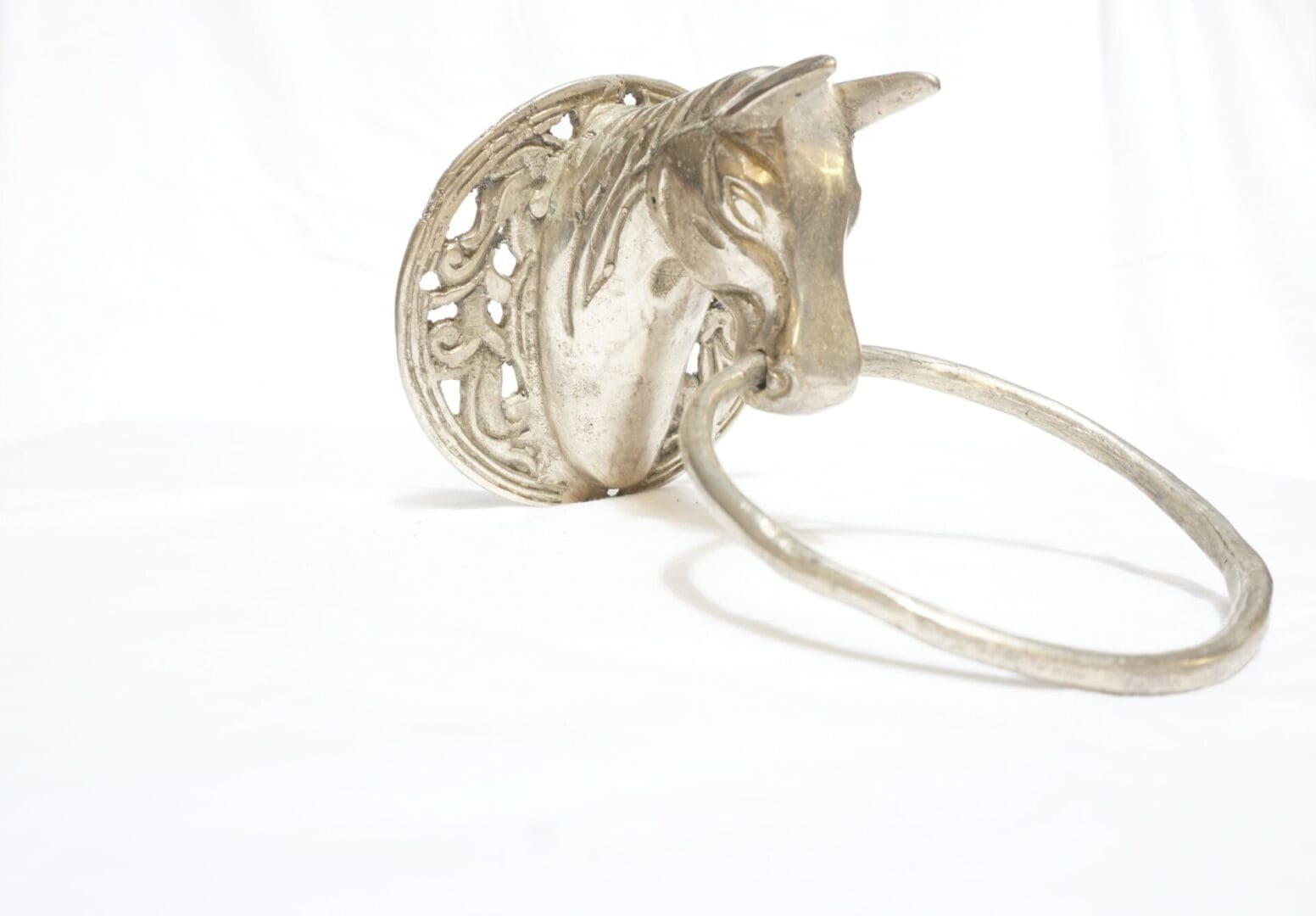 A silver horse head with a white background