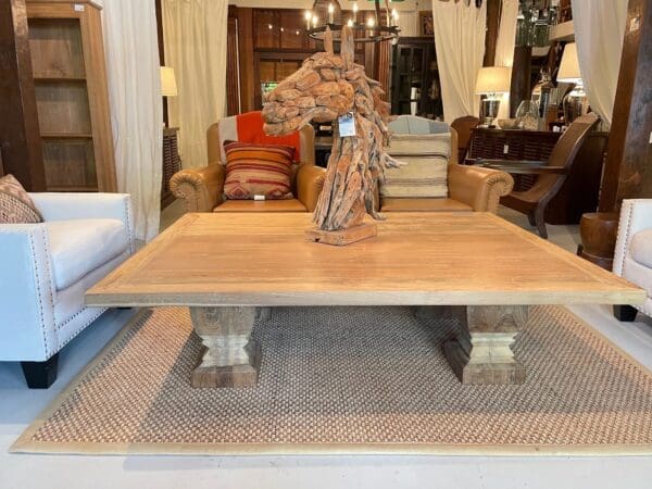 A large wooden coffee table in front of two couches.