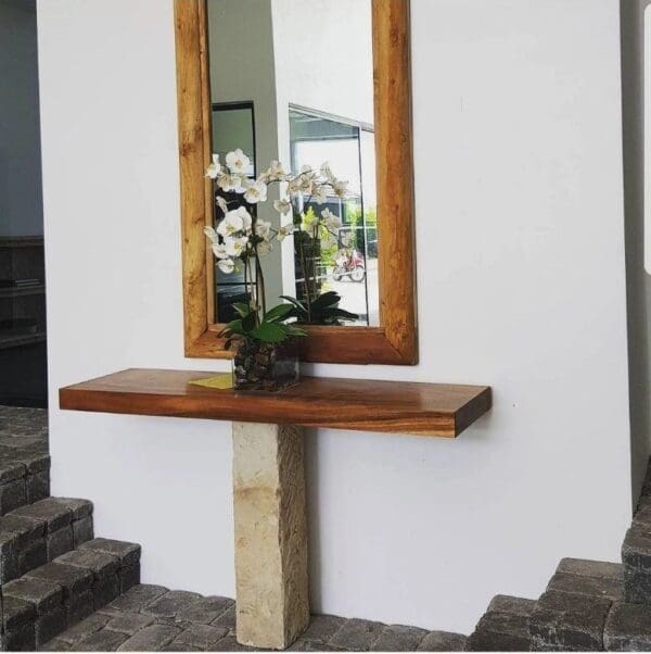 Wooden console table with orchids and mirror.