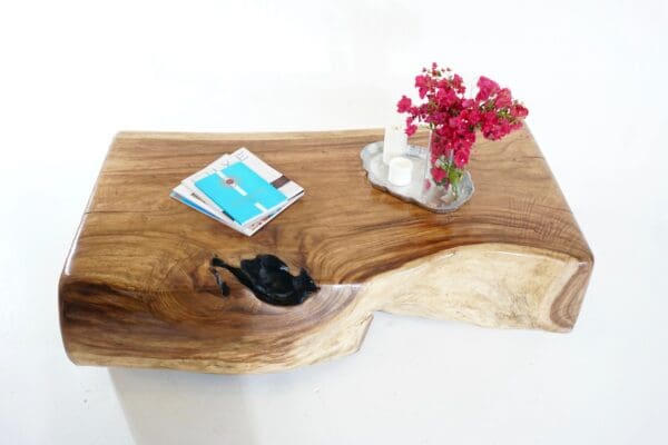 A wooden table with a vase of flowers on top.