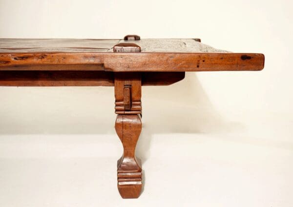 A wooden table with two legs and one leg extended.