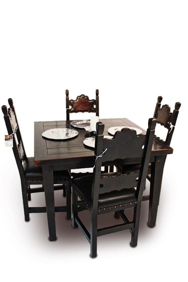 A table with four chairs and plates on top of it.