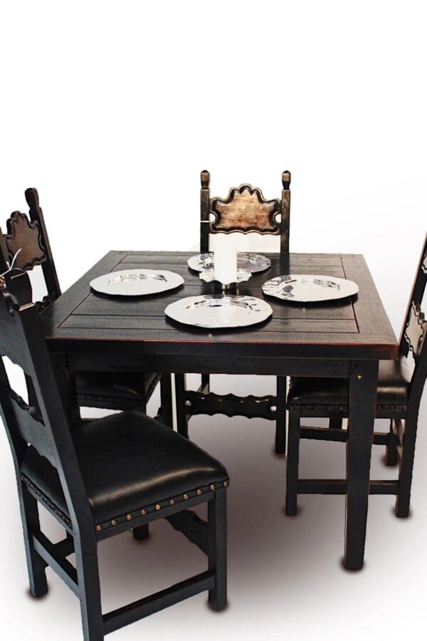 A table with four chairs and plates on top of it.