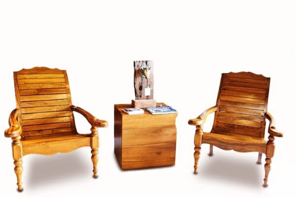 Two wooden chairs and a table with magazines on top of it.