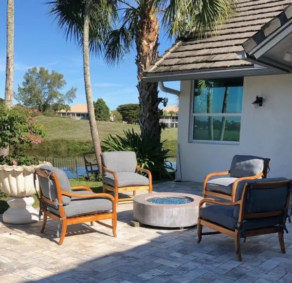 A patio with chairs and a fire pit.