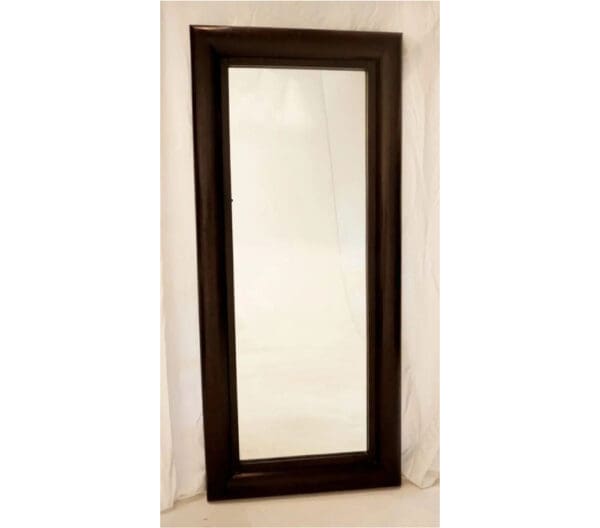 A mirror with a wooden frame on the wall.